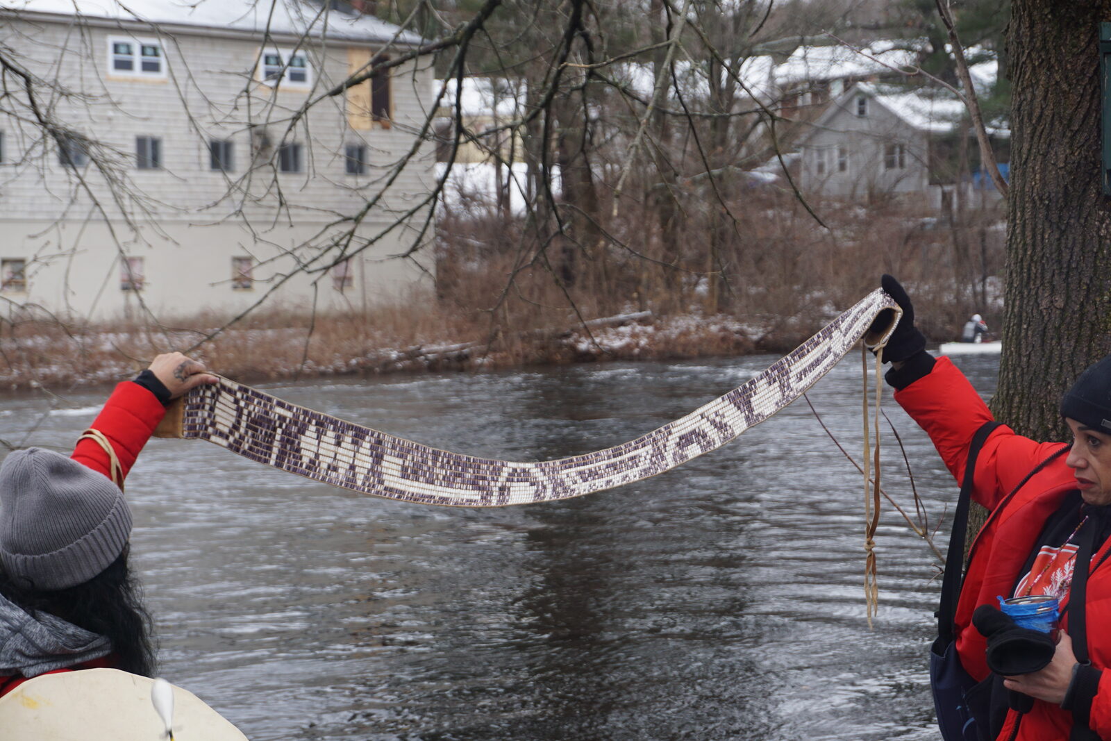 A wampum belt held up along the riverbank during the water ceremony