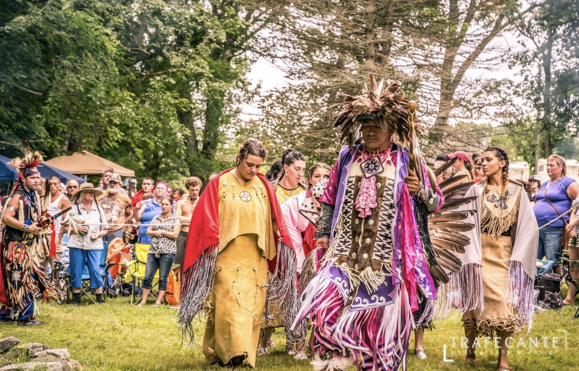 Nipmuc community members in ceremonial regalia processing at a powwow