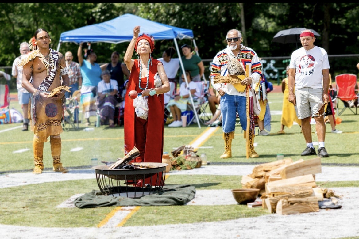 Elders and community members gathered around the ceremonial fire at the powwow