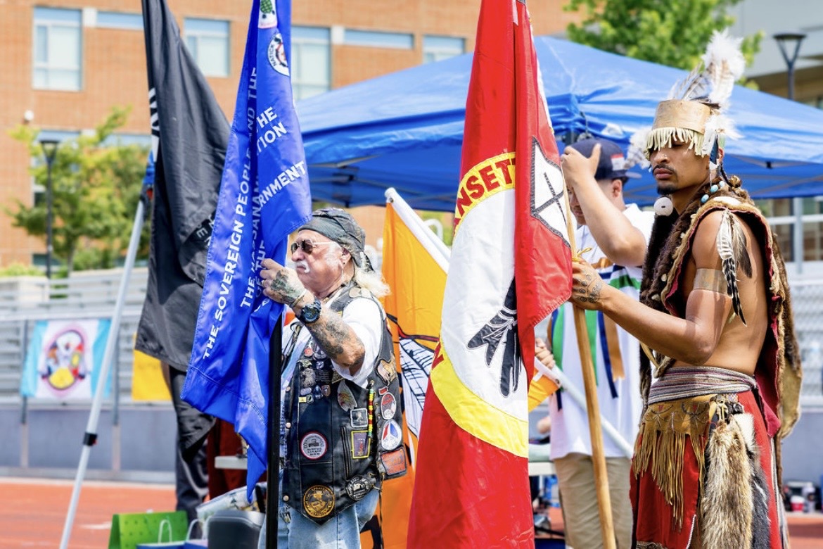 Flag bearers with tribal and veteran flags at the powwow