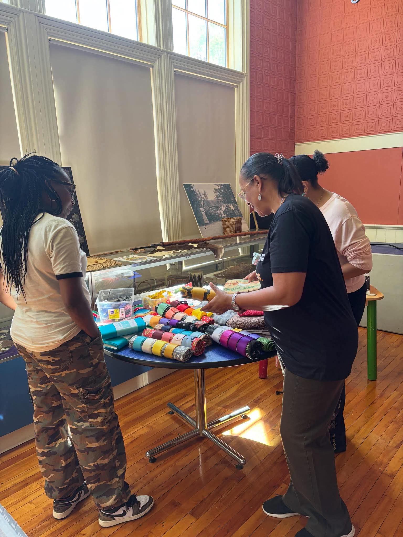 Community members selecting ribbon and fabric for their skirts at the workshop