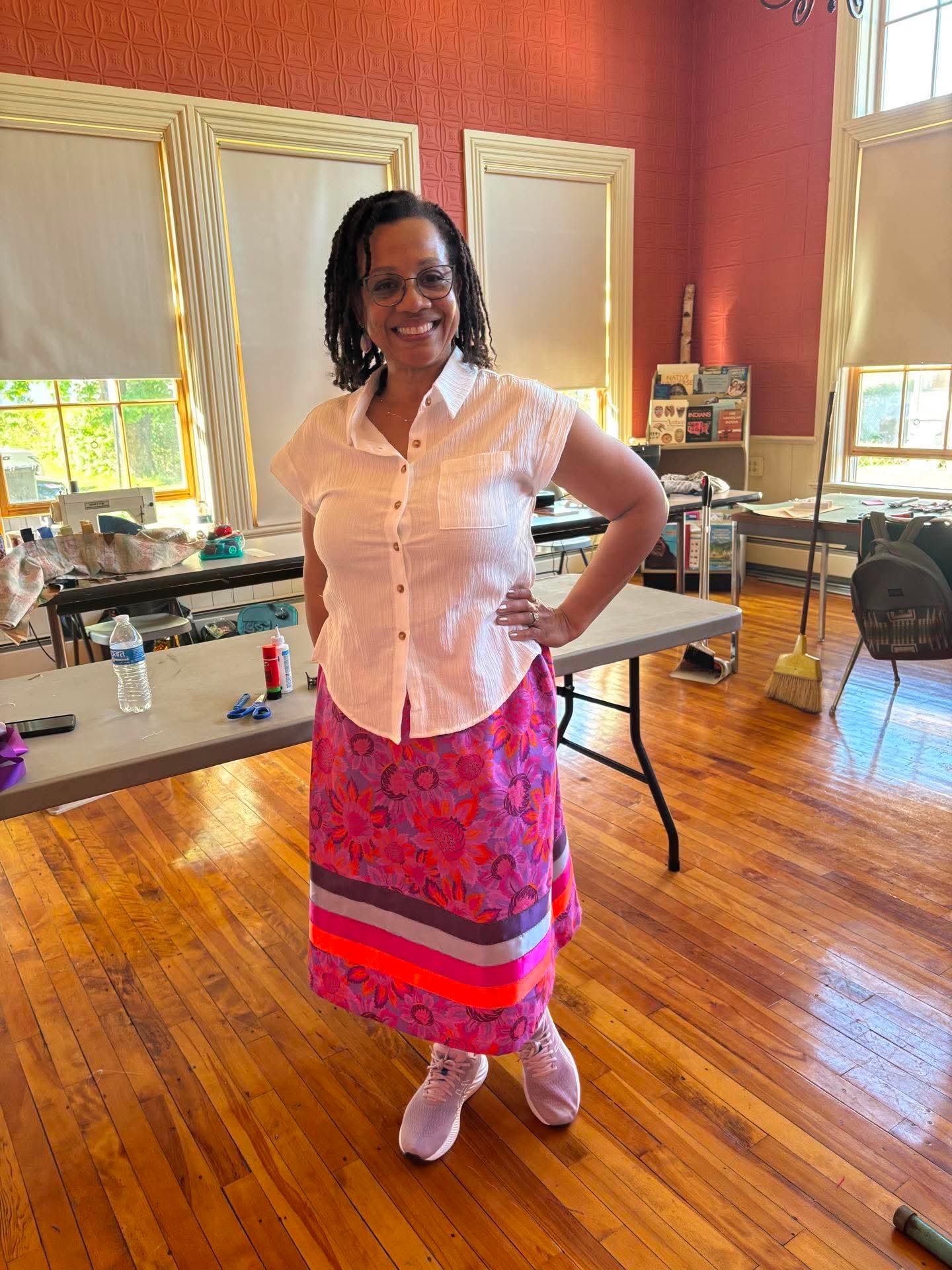 Workshop participant modeling a finished pink and purple floral ribbon skirt
