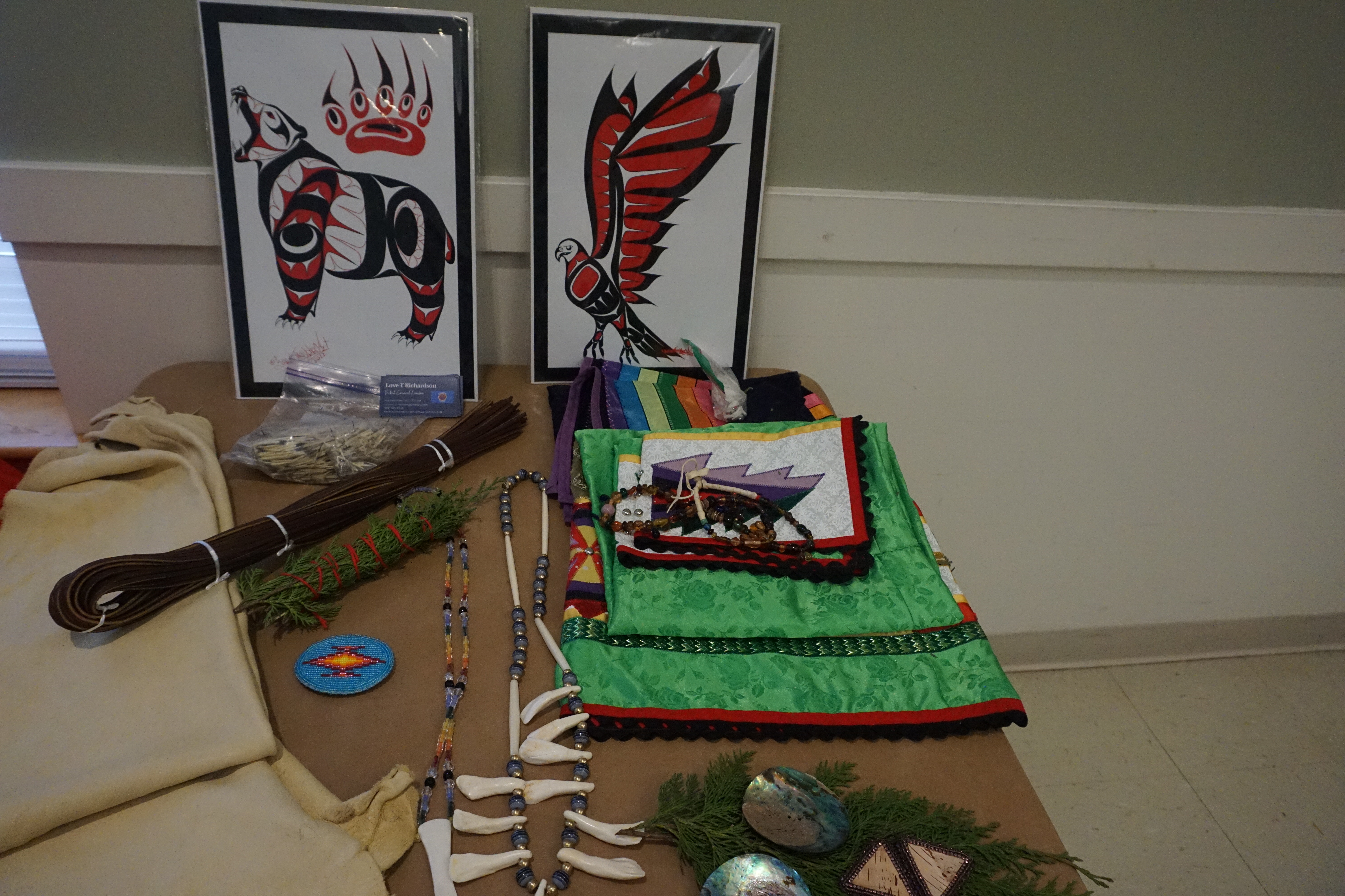 Craft supplies, ribbon, and artwork prints displayed on a vendor table at the Trade Event
